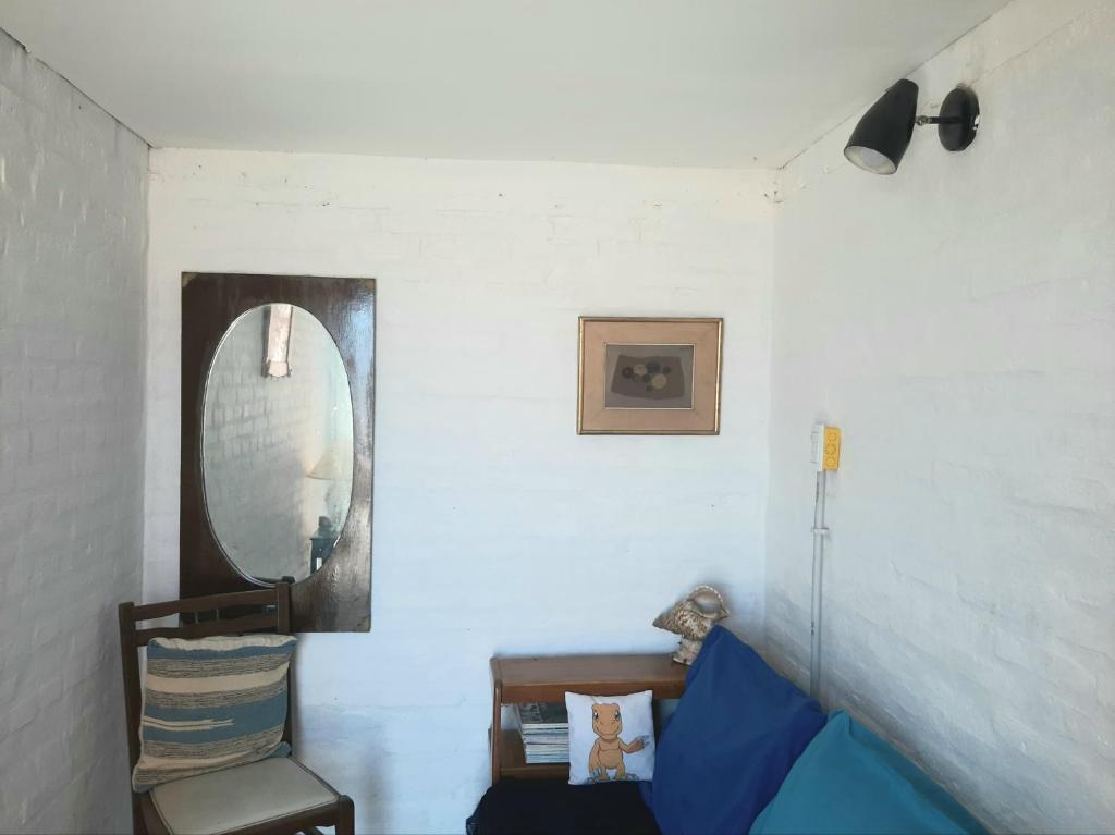 a room with a mirror and a couch and a chair at Masia del Viento in Mar del Sur