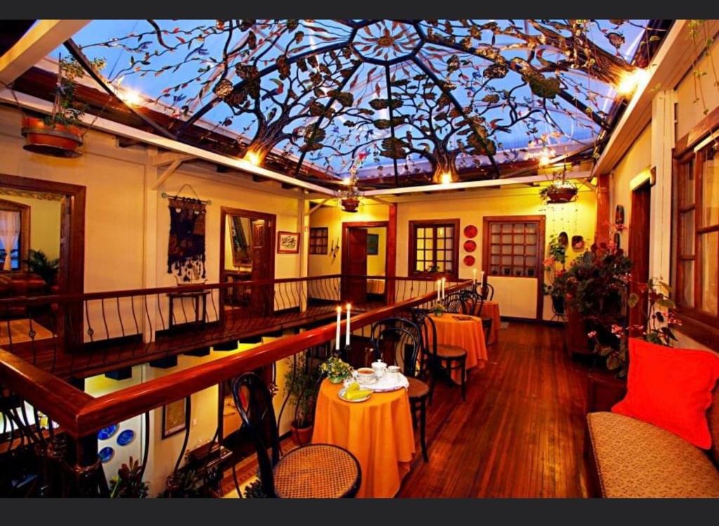 een kamer met tafels en stoelen en een plafond bij Hotel Boutique Portal de Cantuña in Quito