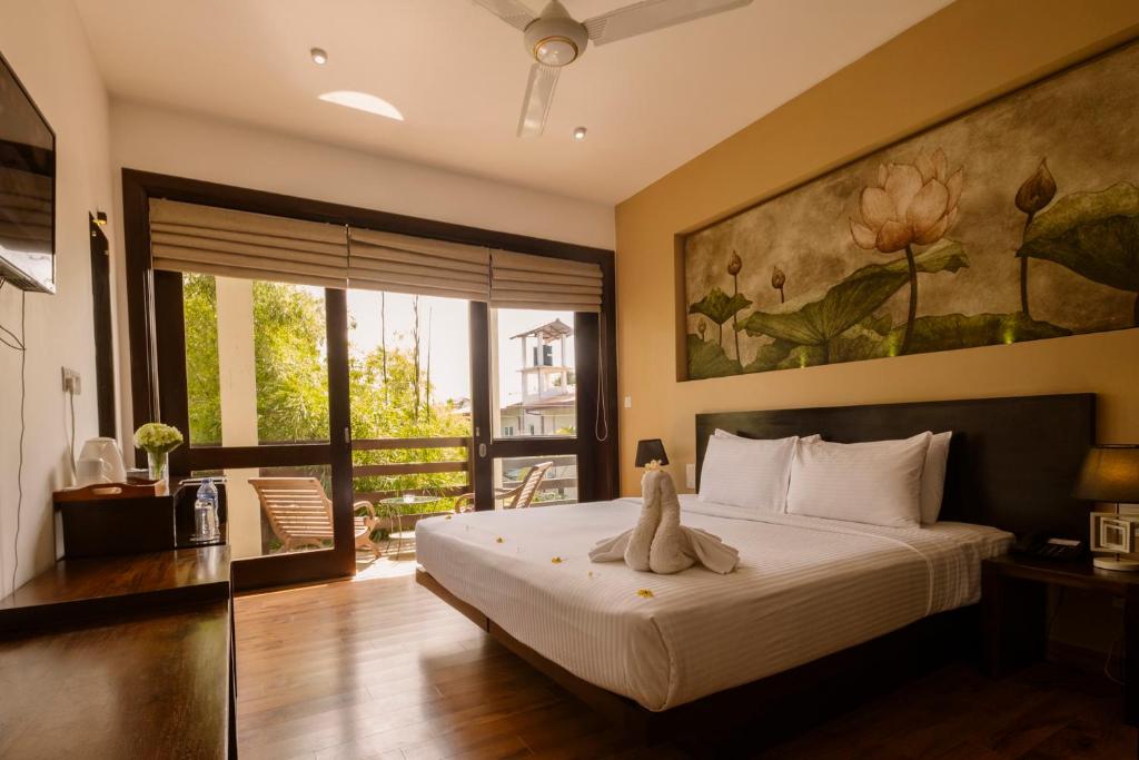 ein Schlafzimmer mit einem Bett mit einem Teddybär drauf in der Unterkunft Terrace Green Hotel & Spa in Negombo