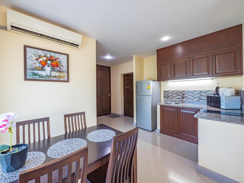 uma cozinha com uma mesa e cadeiras e um frigorífico em Condo AVANTA Deluxe A201 em Ban Tai