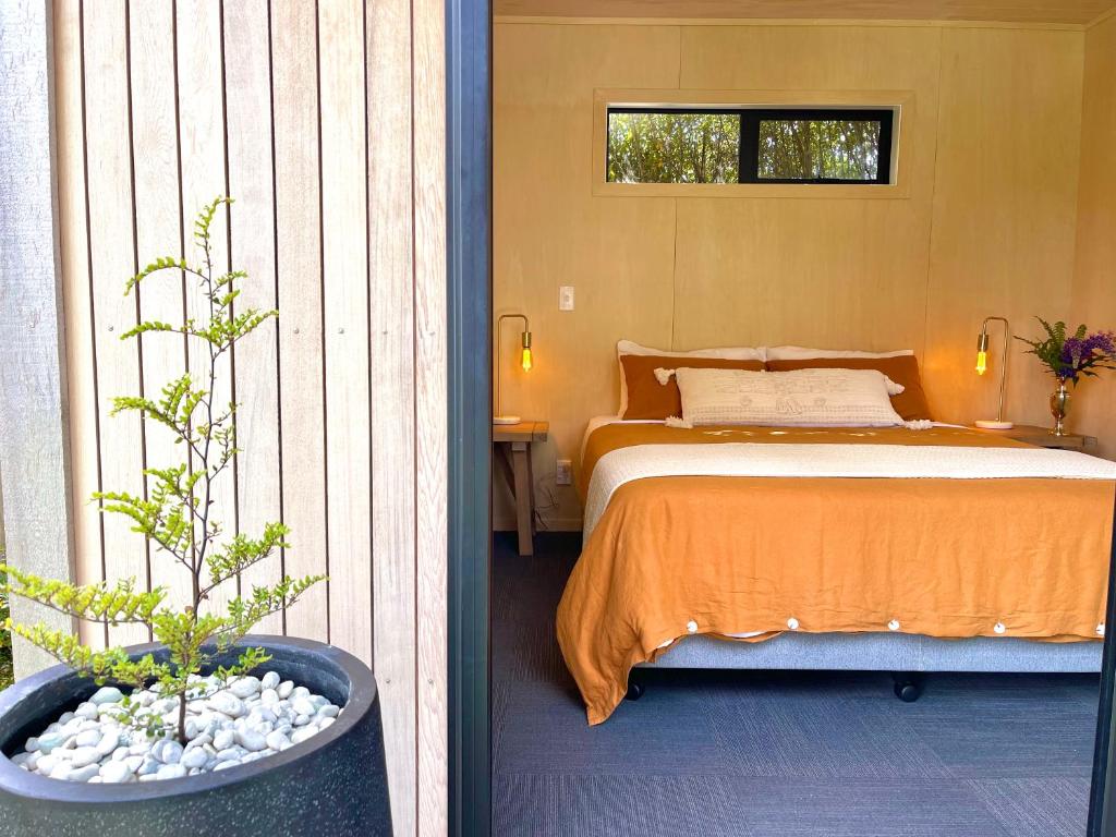 a bedroom with a bed and a potted plant at Te Anau Lakefront Backpackers in Te Anau
