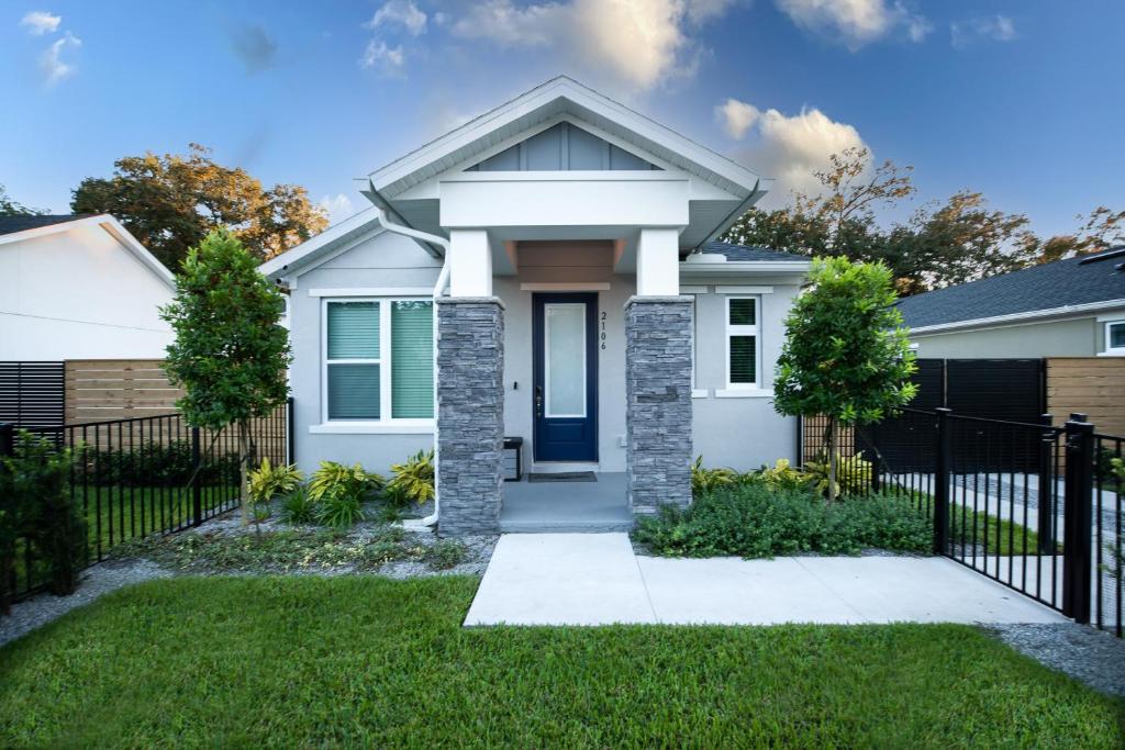 una casa blanca con una valla negra en Newly Constructed Modern Pet Friendly Zen Home with Private Home Theater & Hot Tub! home en Orlando