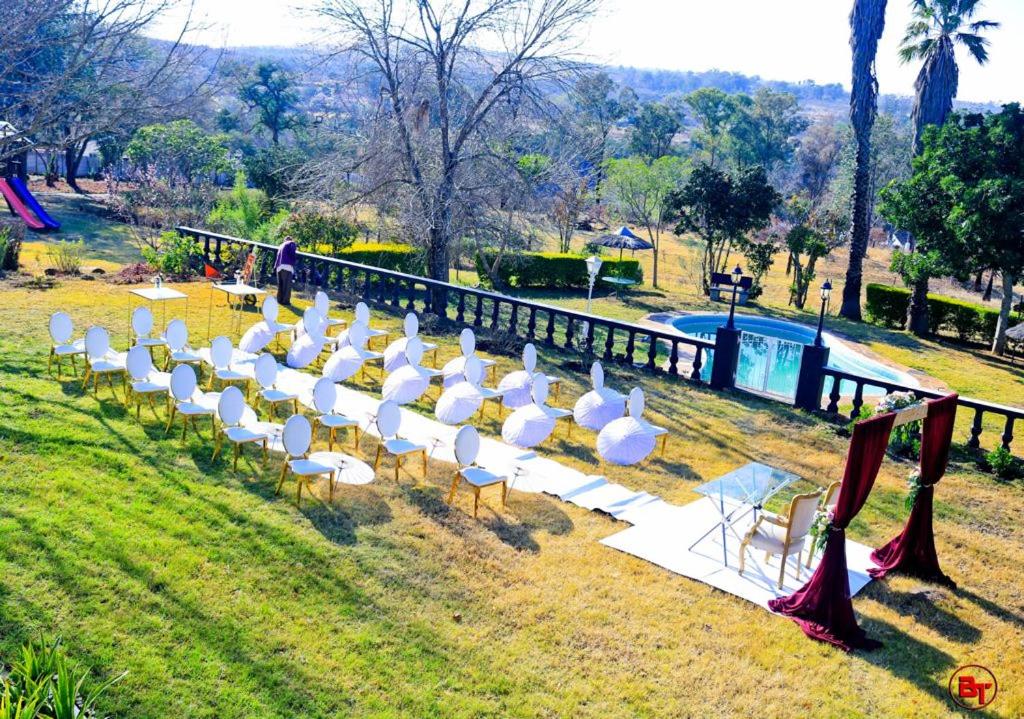 una fila di sedie bianche sedute nell'erba di BougainVilla Guest House a King Williamʼs Town