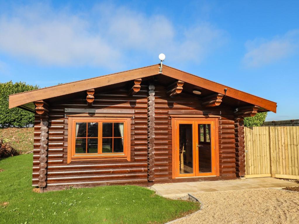 a log cabin with a pitched roof and windows at Oak Lodge in Oakham