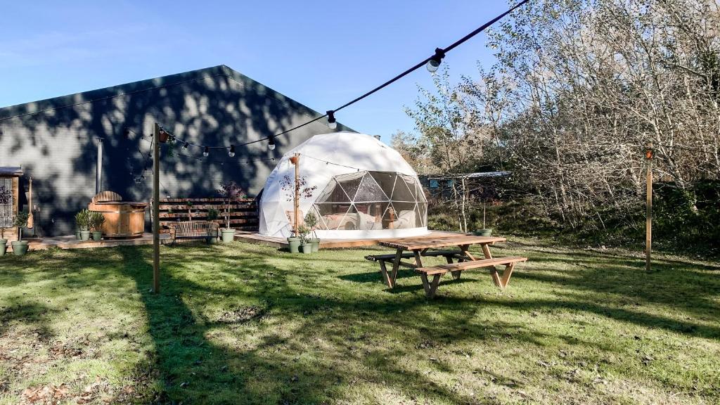 een houten picknicktafel voor een iglo bij Romantische glamping dome Koksijde - Duiniek in Koksijde