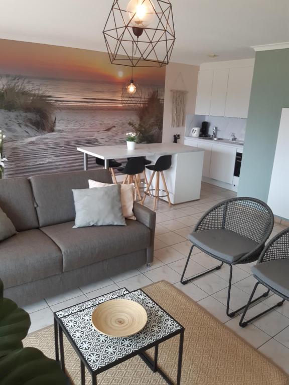 a living room with a couch and a table at residentie Den Oever in Nieuwpoort