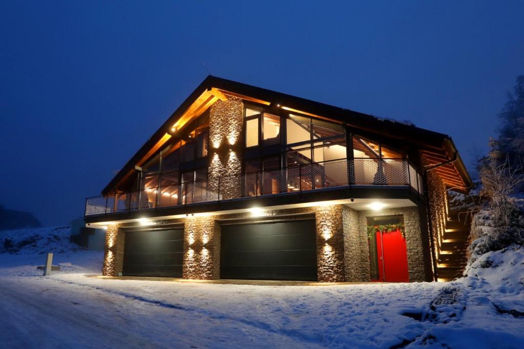 a house with a red door in the snow at Vila Pohoda in Donovaly