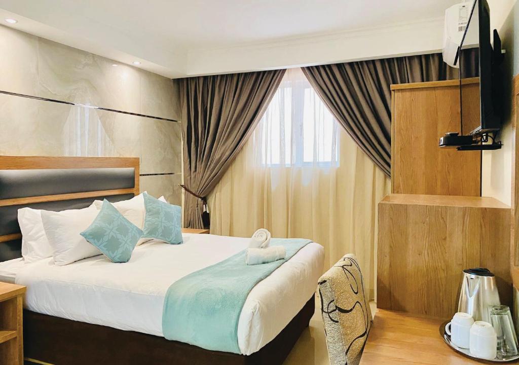 Bayside Hotel 116 West Street في ديربان: غرفة نوم عليها سرير وتلفزيون