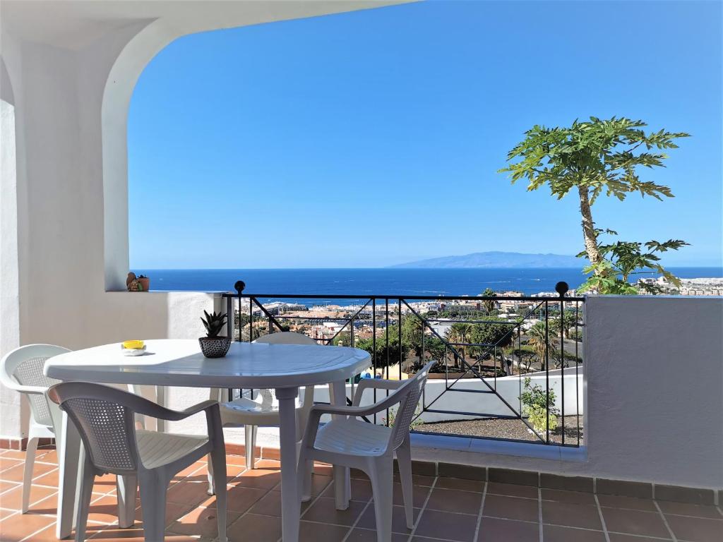 a table and chairs on a balcony with a view of the ocean at Panoramic View Balcón del Atlántico in Adeje
