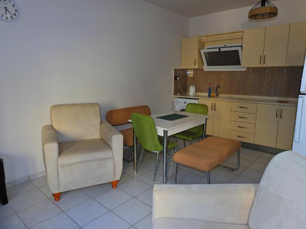 Il comprend un salon avec une table et des chaises ainsi qu'une cuisine. dans l'établissement Ertunalp Apartment, à Famagouste