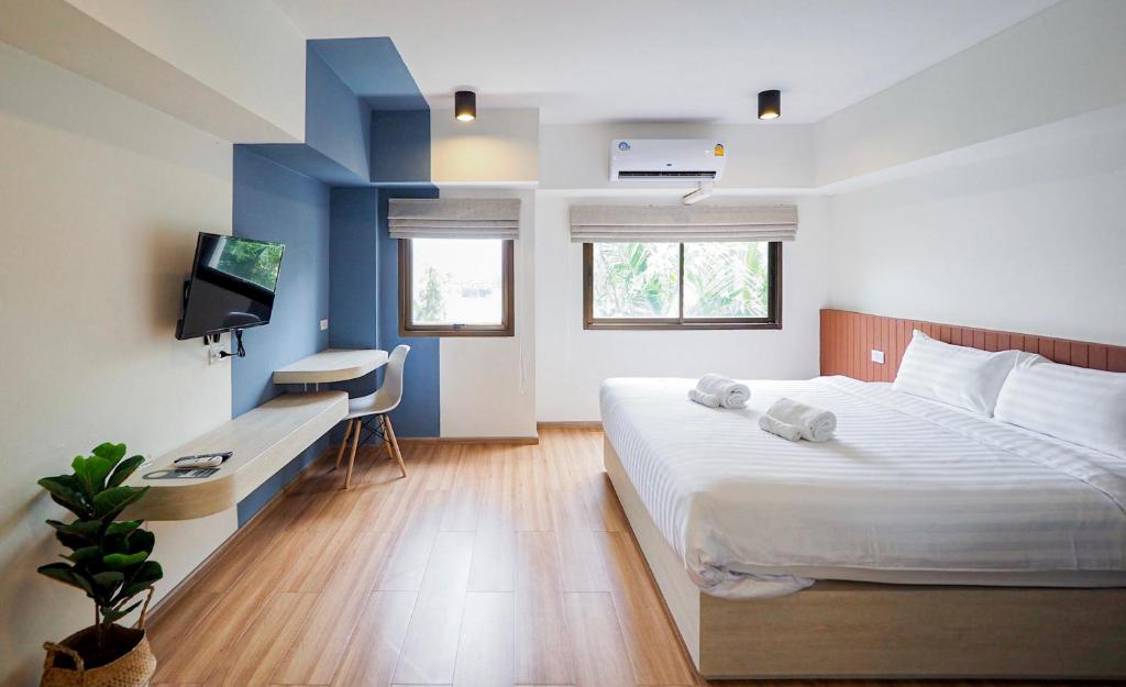 a bedroom with a bed and a desk and a tv at Saffron Hill Minburi in Min Buri