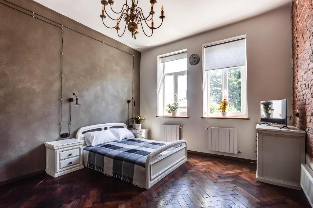 a bedroom with a bed and two windows at Green Garden !svitlo postiyno! in Lviv