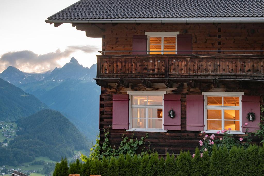 une maison avec un balcon et des montagnes en arrière-plan dans l'établissement Chalet "Altes Schulhaus", à Schruns