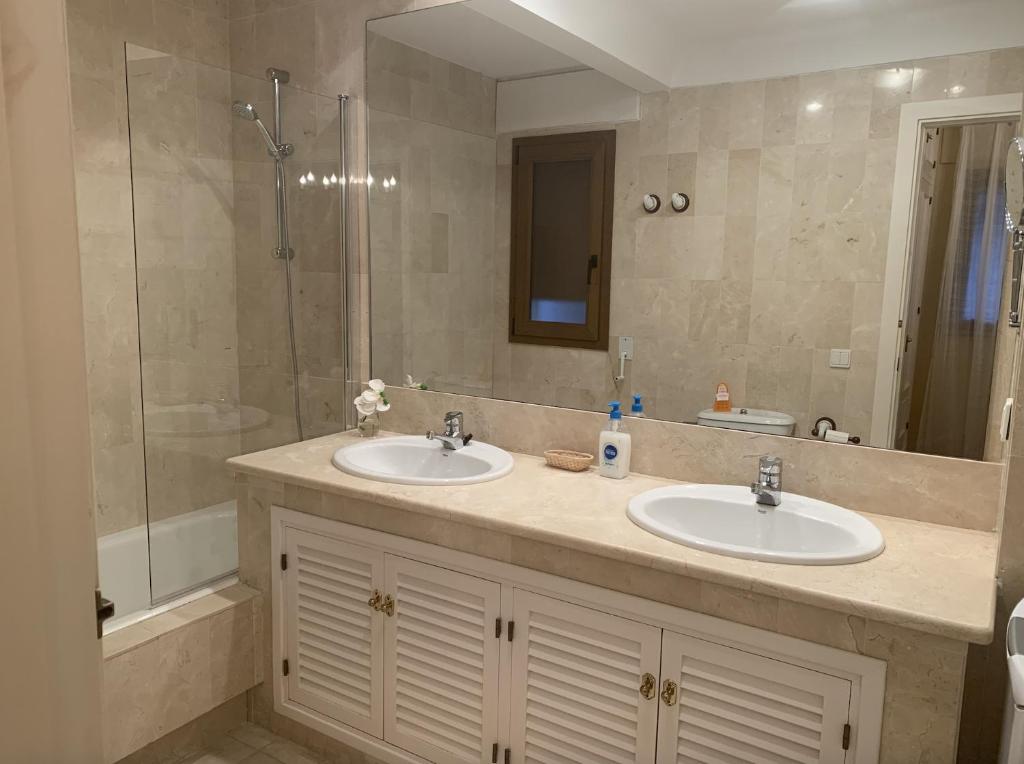 een badkamer met twee wastafels en een douche bij Comodo apartamento en Bahia de la Plata in Zahara de los Atunes