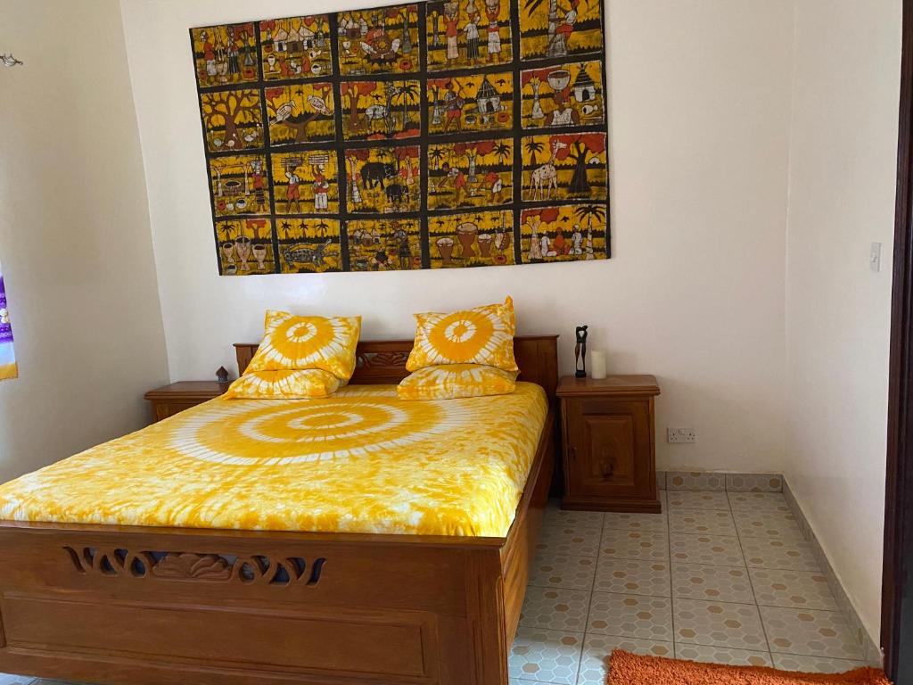 sypialnia z łóżkiem z obrazem na ścianie w obiekcie Dabo House w mieście Brufut