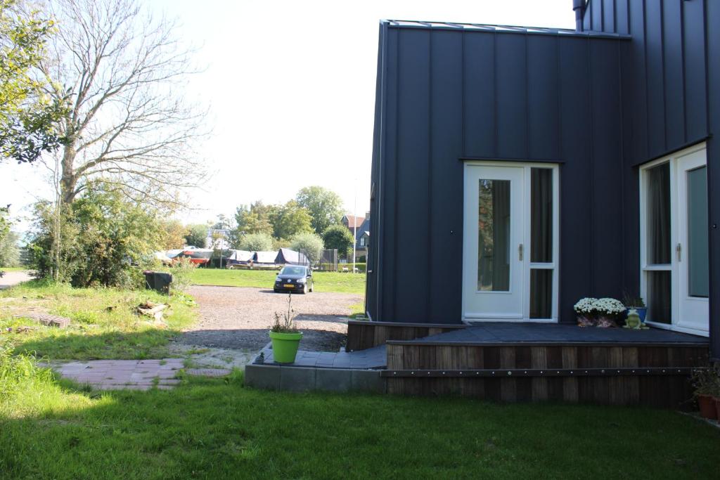 uma casa preta com uma porta da frente e um quintal em BakBoord em Grou