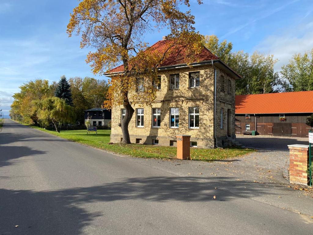 an old stone building with a red roof on a street at Ferienwohnung am Froser See in Frose