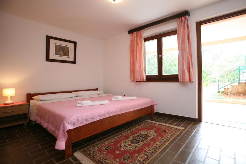 a bedroom with a bed and a large window at Apartments Neda - Poreč South in Poreč