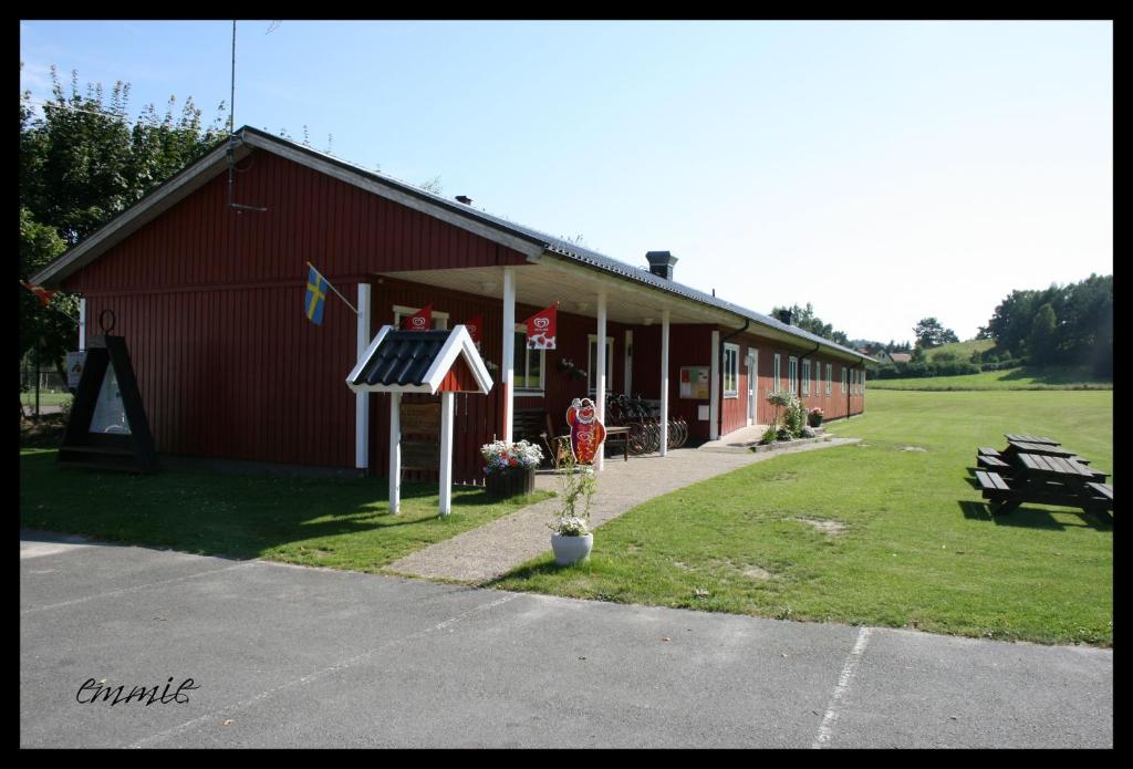 een rood gebouw met een bord ervoor bij Degeberga Vandrarhem in Degeberga