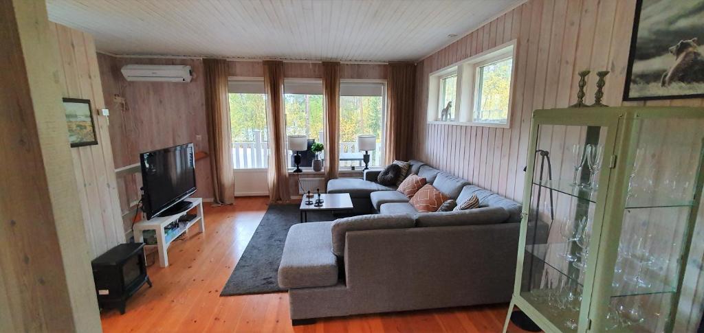 a living room with a couch and a tv at Fjällstuga i Foskros m bastu in Idre