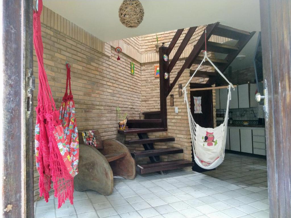 a room with a staircase and a kitchen with red curtains at Apartamento/Duplex Praia do Francês in Praia do Frances