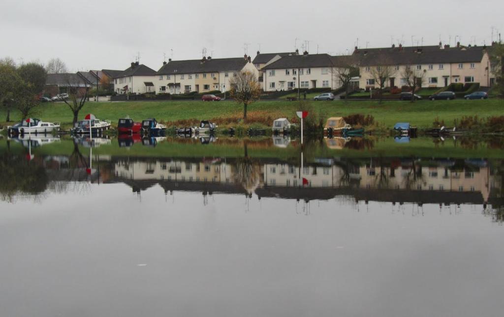 ein großer Wasserkörper mit Häusern im Hintergrund in der Unterkunft Riverview House in Enniskillen