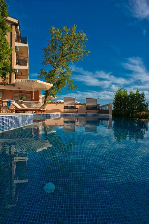 a swimming pool in front of a building at Harmonia Bungalows & Pool in Sveti Stefan