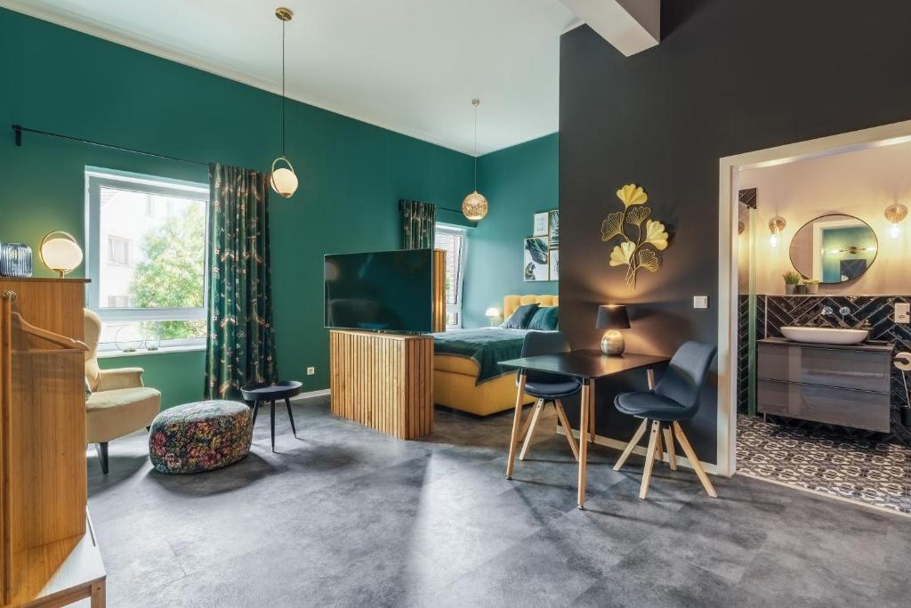 ein Wohnzimmer mit grünen Wänden und ein Schlafzimmer in der Unterkunft One Moment Boardinghouse - Apartment Tropic in Porta Westfalica