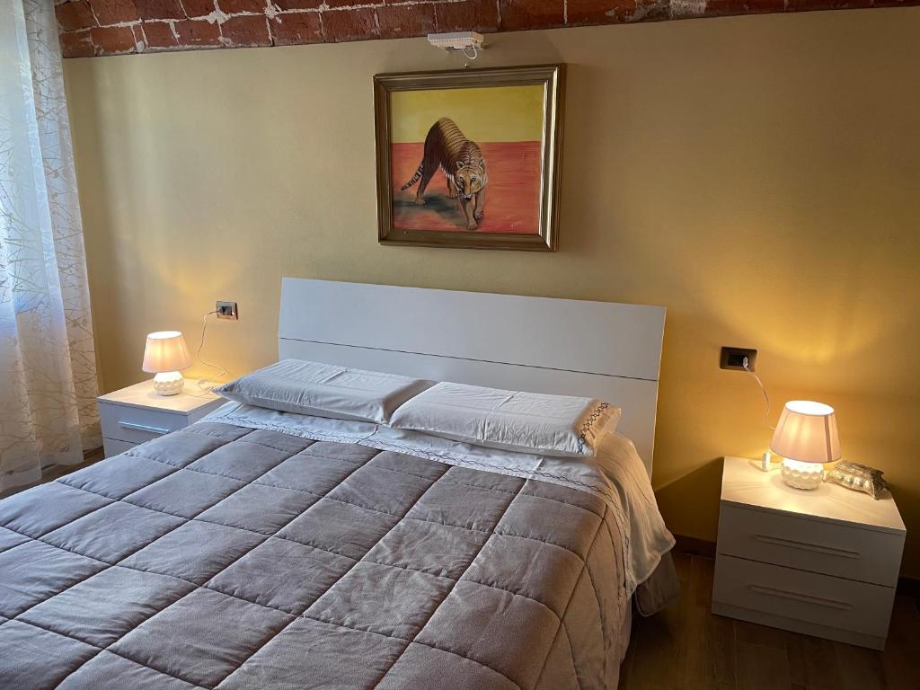 Un dormitorio con una cama grande con dos mesitas de noche. en Residenza Nikol, en Casale Monferrato