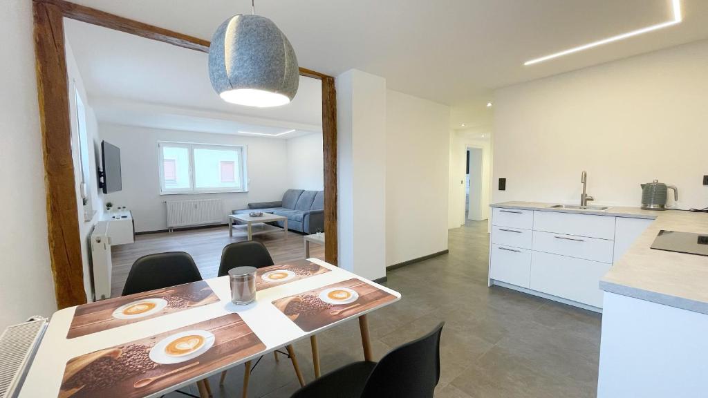 - une salle à manger et une cuisine avec une table et des chaises dans l'établissement Uraha Apartments Seukendorf, à Seukendorf