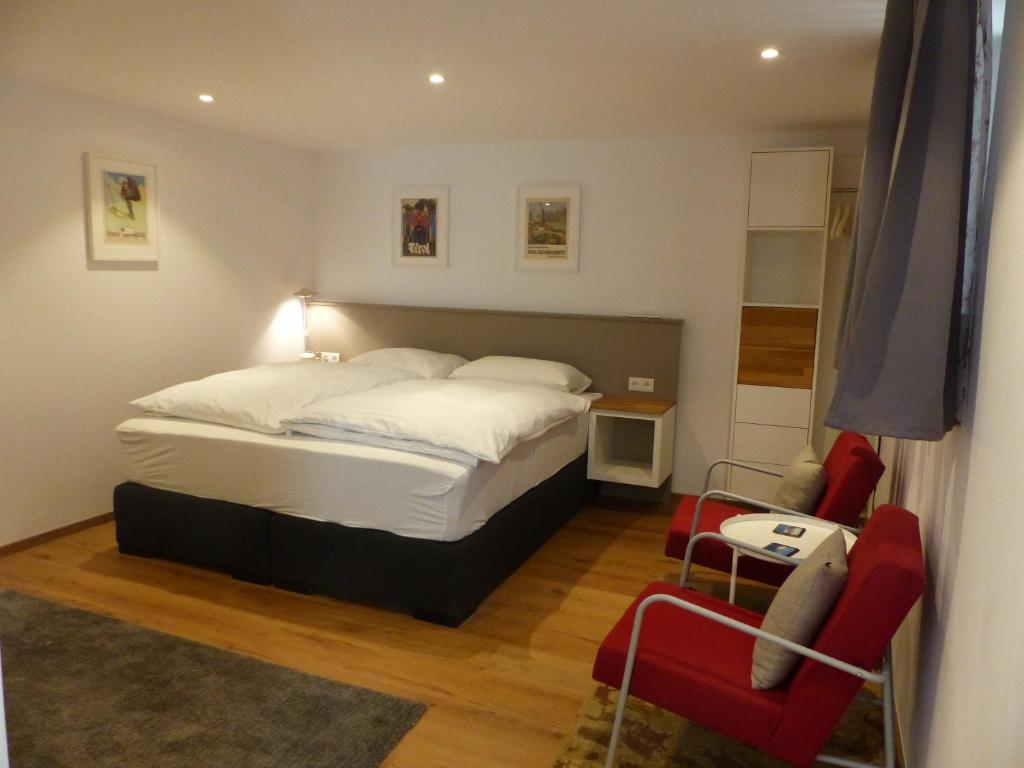 una camera con un letto e due sedie rosse di Gstill-4-Living a Innsbruck