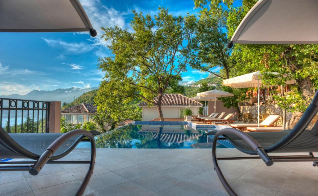 a swimming pool with lounge chairs next to a house at Harmonia Bungalows & Pool in Sveti Stefan