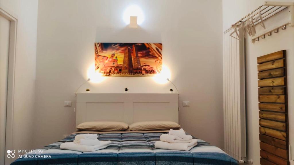 1 dormitorio con 1 cama con una pintura en la pared en CASA SAVENA, en Bolonia