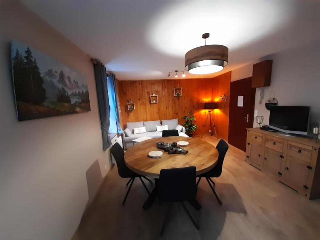 een woonkamer met een tafel en een bank bij Chez la malou in La Bresse