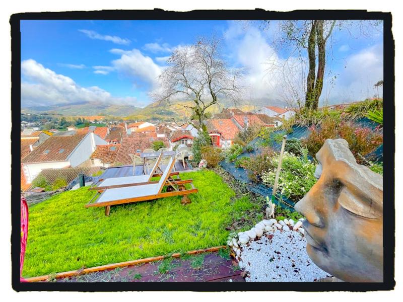 a statue of a head and a bench in a yard at Chambres d'Hôtes Maison E.Bernat in Saint-Jean-Pied-de-Port