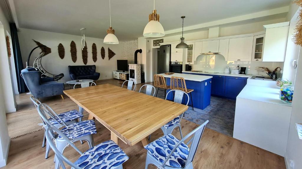 a kitchen and dining room with a wooden table and chairs at Jadamowo, w 2h od Warszawy i Gdańska, Mazury House z kominkiem in Olsztynek