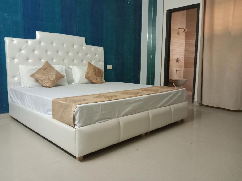 uma cama branca com uma cabeceira branca num quarto em City Palace em Panchkula