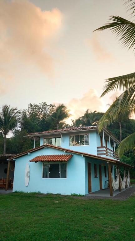 una casa blanca con palmeras delante en Welove Beach House-Pés na areia Quintal dos Sonhos en Serra Grande