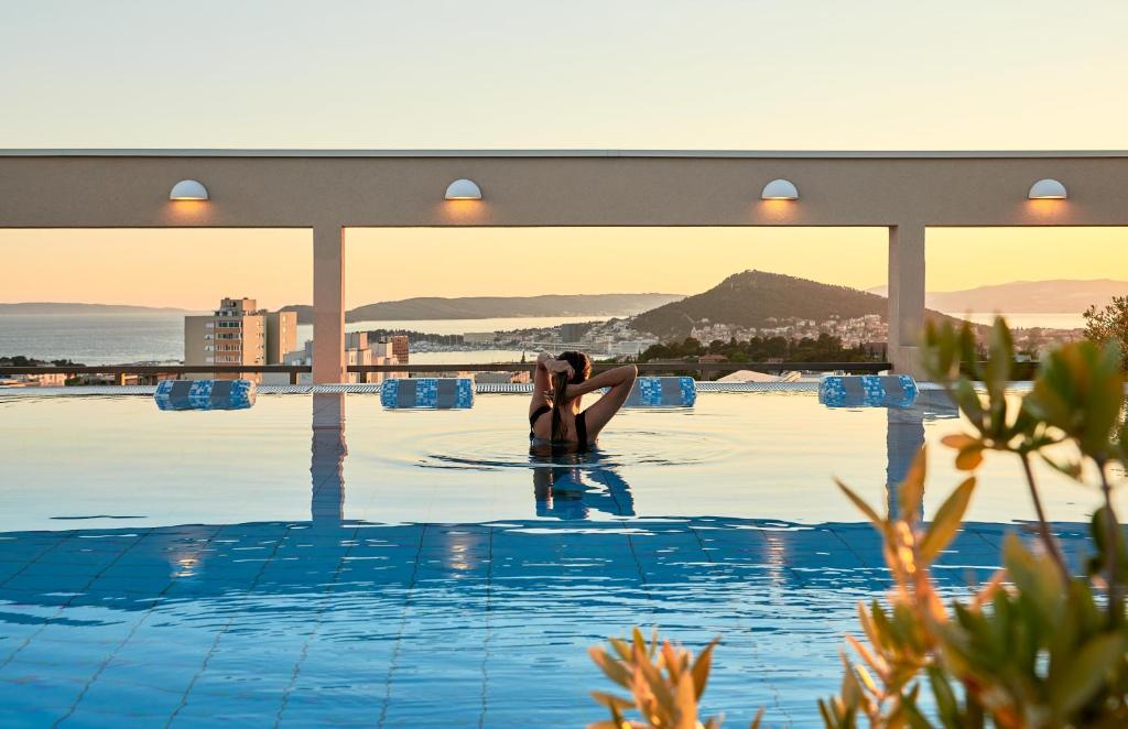 una pareja en la piscina en un hotel en Dioklecijan Hotel & Residence en Split