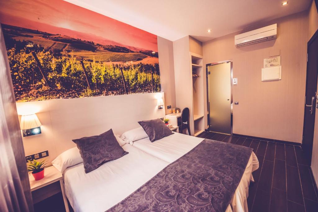 a hotel room with a bed and a painting on the wall at Hostal Prado in Madrid