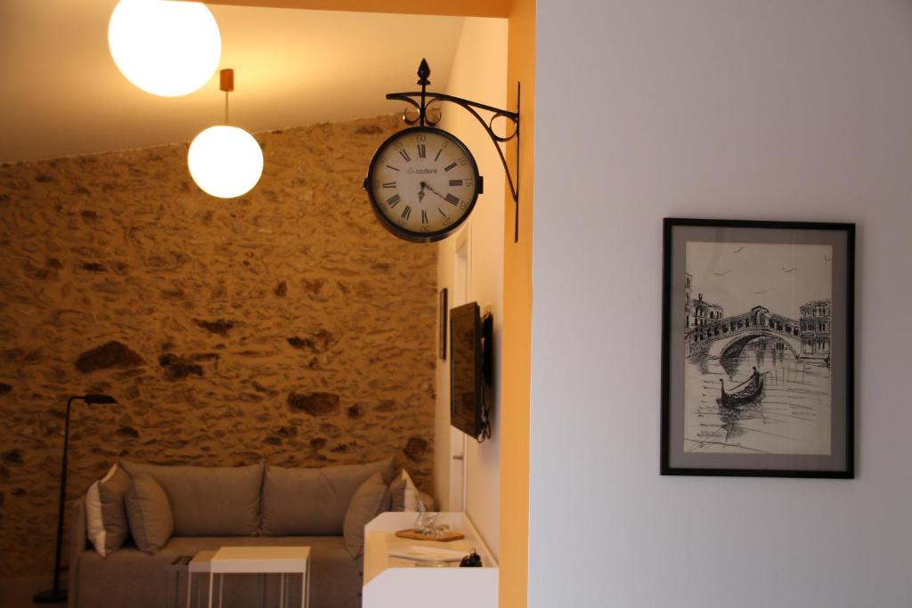 a living room with a couch and a clock on the wall at la pedrera in Espolla