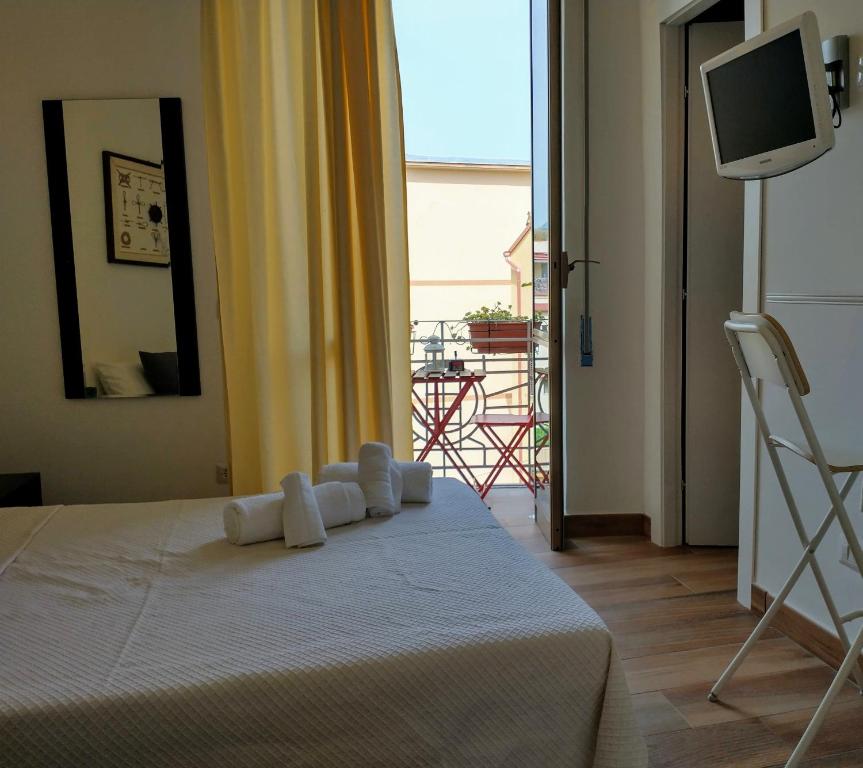 een slaapkamer met een bed, een televisie en een balkon bij Mi casa tu casa in Formia