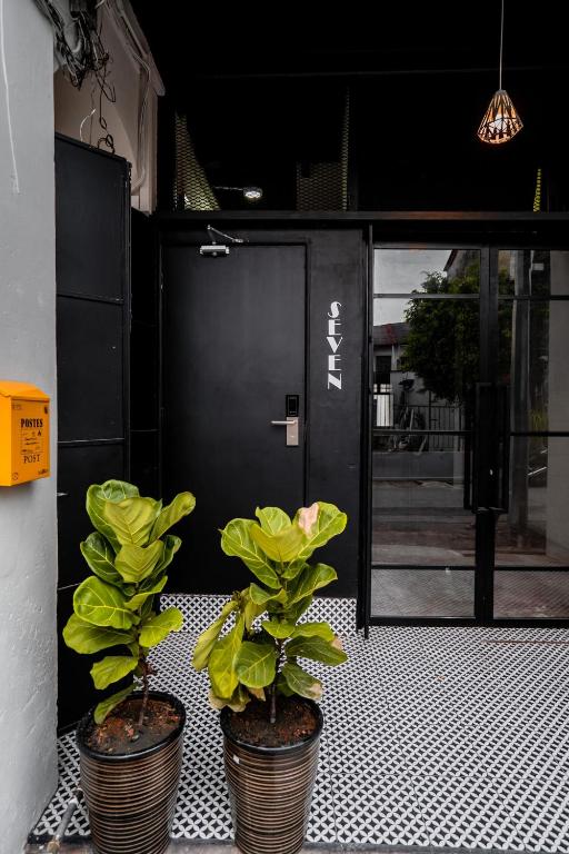 two potted plants sitting in front of a door at Chulia Heritage Studio in George Town
