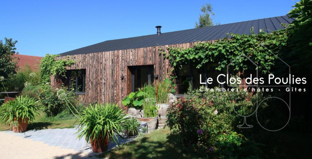 a wooden building with plants in front of it at Clos des Poulies in La Ferté-Saint-Aubin