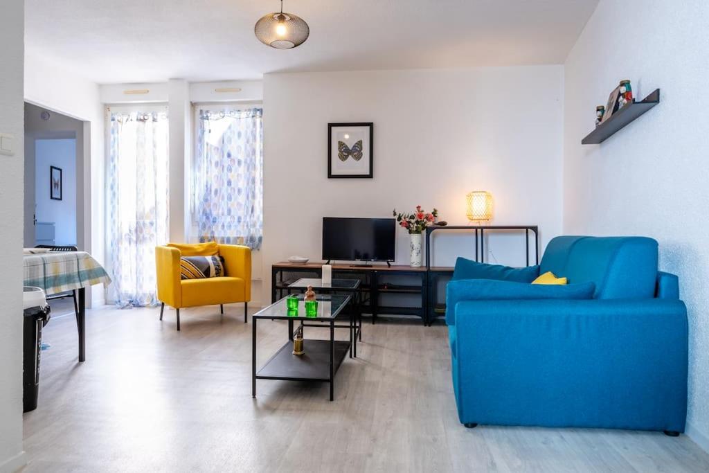 - un salon avec un canapé bleu et des fauteuils jaunes dans l'établissement La Station - Lourdes - Centre - Residence Serenity, à Lourdes