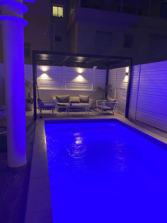 a swimming pool with blue lights in a house at Luxury Duplex With Private Pool in Eilat
