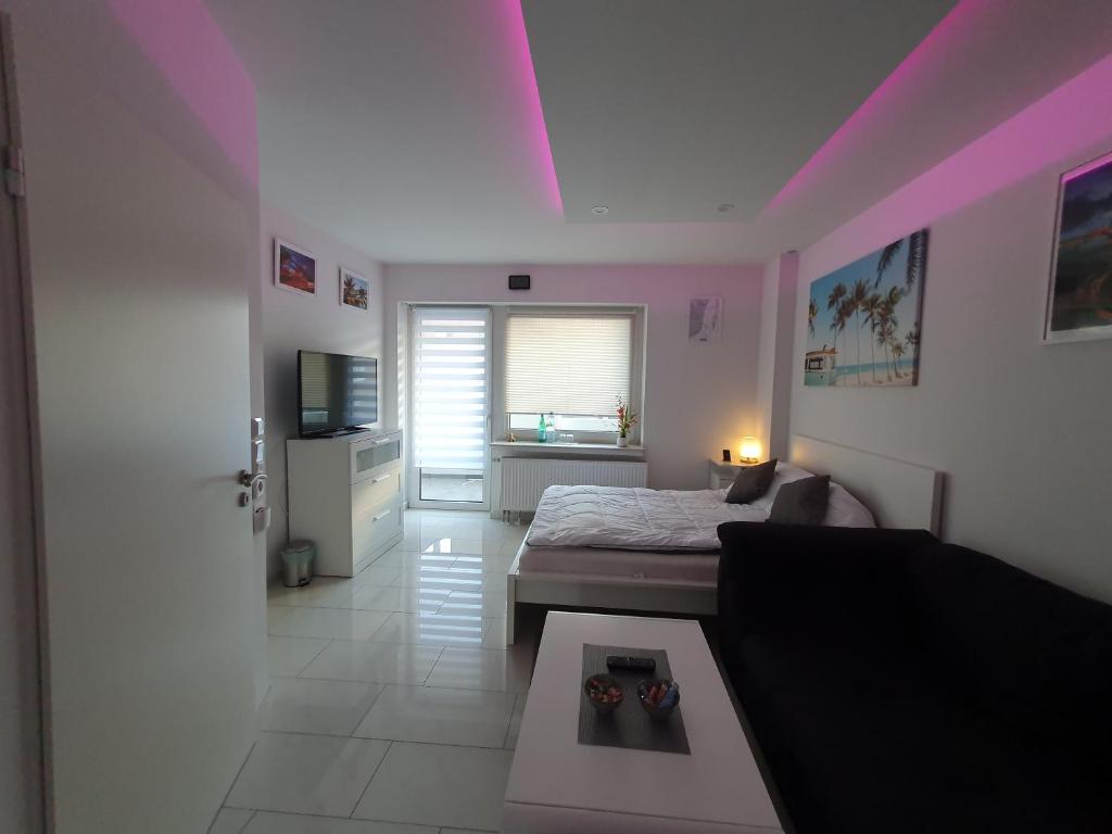 une chambre avec un lit et une chambre avec un canapé dans l'établissement Miami Apartment, à Paderborn