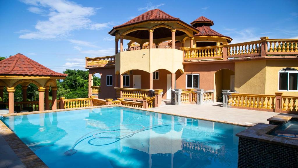 a large house with a swimming pool and a gazebo at Ocean View Terrace in Montego Bay