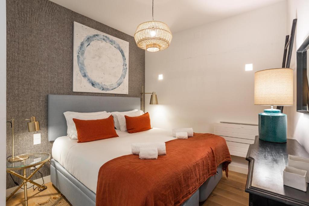 - une chambre avec un grand lit et des oreillers orange dans l'établissement Chic Tailor Made Flat in Chiado, à Lisbonne