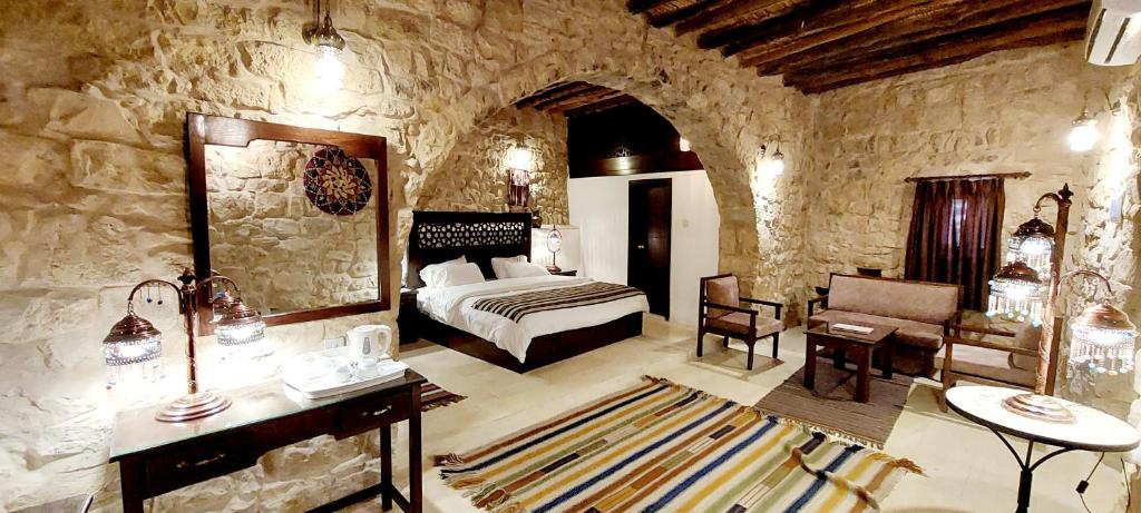 Hayat Zaman Hotel And Resort Petra في وادي موسى: غرفة نوم بسرير وكرسي في غرفة